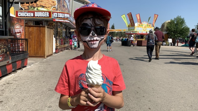 Un enfant tient une crème glacée dans une allée du Stampede.