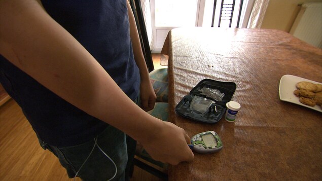 Un garçon utilise un glucomètre.