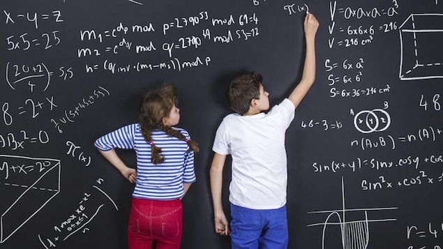 Deux enfants écrivent au tableau