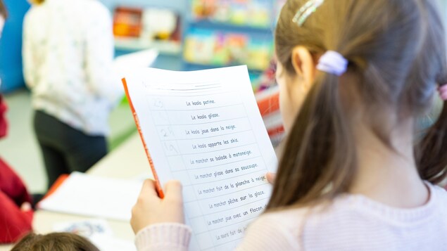 Une élève observe son exercice de français. 