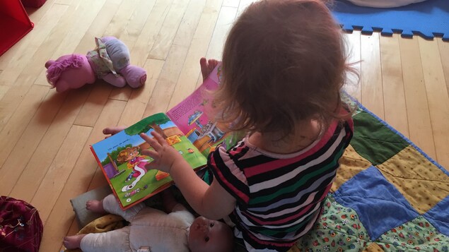 Une enfant qui feuillette un livre