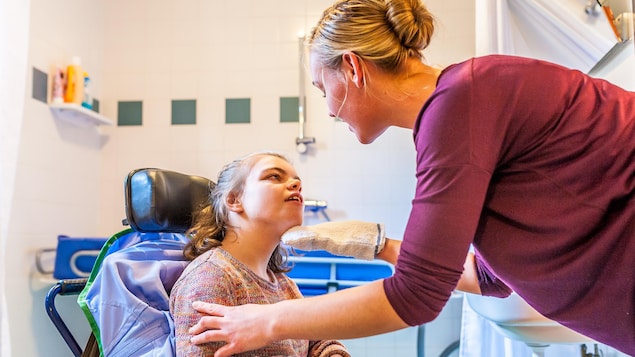 Une femme s'occupe d'une enfant handicapée