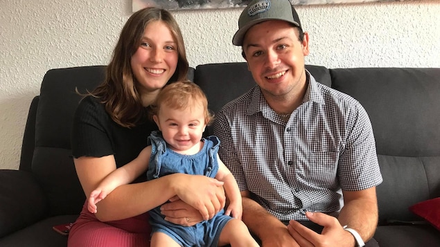 Un enfant dans les bras de ses parents.
