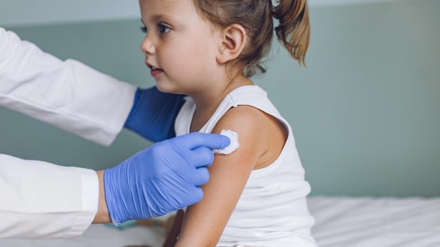 Une petite fille reçoit une dose de vaccin.