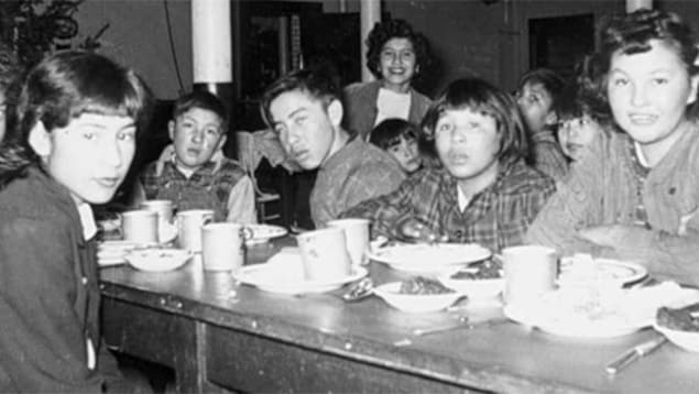 Des enfants prennent le repas au pensionnat de la réserve Gordon, géré par l'Église anglicane du Canada, en Saskatchewan, en 1945.