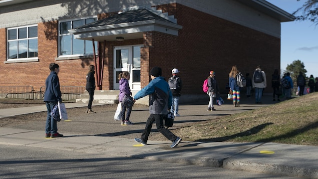 Des jeunes écoliers gardent une bonne distance entre-eux en ce jour de rentrée scolaire.