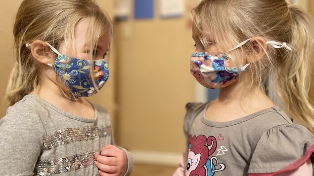Deux enfants qui portent un masque.