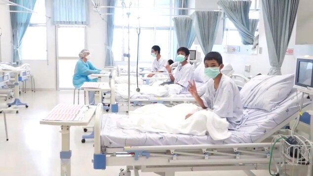 Trois des12 garçons rescapés posent dans une chambre d'hôpital en Thaïlande. Trois des12 garçons rescapés posent dans une chambre d'hôpital en Thaïlande.