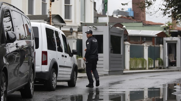 Un policier marche dans une rue, prêt d'un fourgon de la police. Un policier marche dans une rue, prêt d'un fourgon de la police.