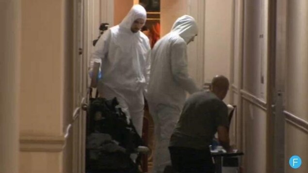 Des policiers près de la porte d'entrée d'un appartement Des policiers près de la porte d'entrée d'un appartement