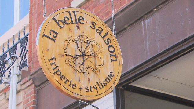 Une enseigne de magasin sur laquelle il est écrit La belle saison.