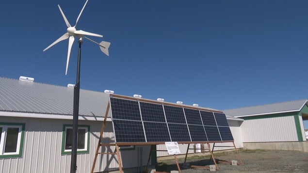 Des panneaux solaire et une éolienne, à l'extérieure de la bergerie