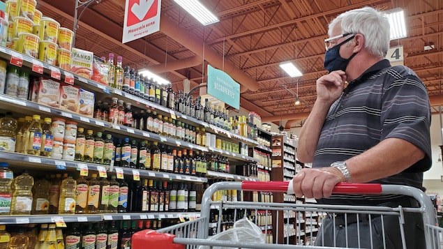 Un homme portant un masque fait ses courses.