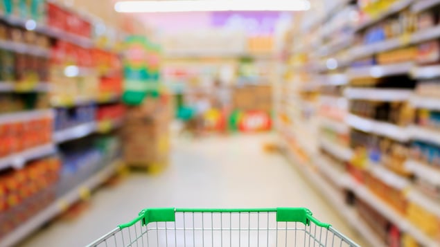 Un panier à roulettes dans une allée d'épicerie