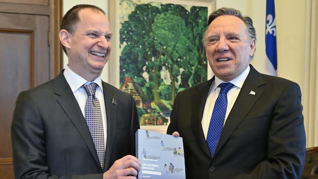 Quebec Finance Minister Eric Girard, left, and Quebec Premier François Legault hold a copy of the budget. This is Girard's fifth budget as finance minister and the first in the CAQ's second term. (Jacques Boissinot/The Canadian Press)