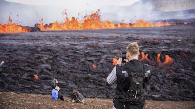 People take a picture of lava flowing.