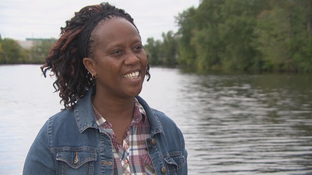 Espérance Nkinabacura répond aux questions d'un journaliste devant la rivière des Outaouais Espérance Nkinabacura répond aux questions d'un journaliste devant la rivière des Outaouais