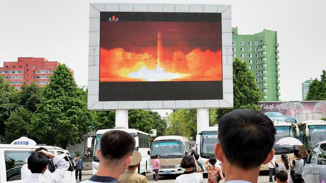 Des Nord-Coréens regardent sur un écran géant ce qui serait le plus récent essai de missile de leur pays.