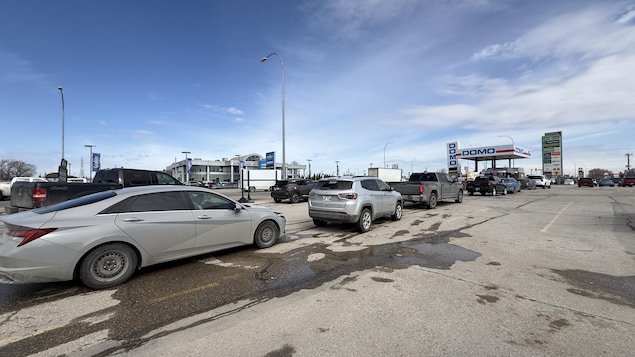 Plusieurs dizaines d'automobilistes faisaient la queue à une station-service Domo à Winnipeg le 20 avril 2026 après la suppression temporaire de la taxe d'accise fédérale sur l'essence.
