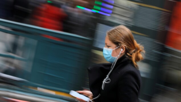 Une femme porte un masque chirurgical à New York.
