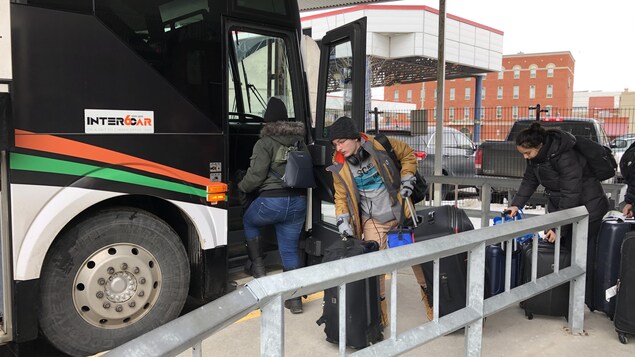 Des étudiants qui montent à bord d'un autobus d'Intercar.