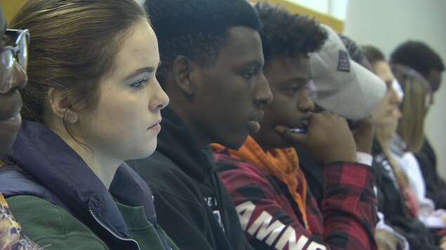 Plusieurs étudiants assis dans une salle de classe, dont quelques étudiants internationaux.