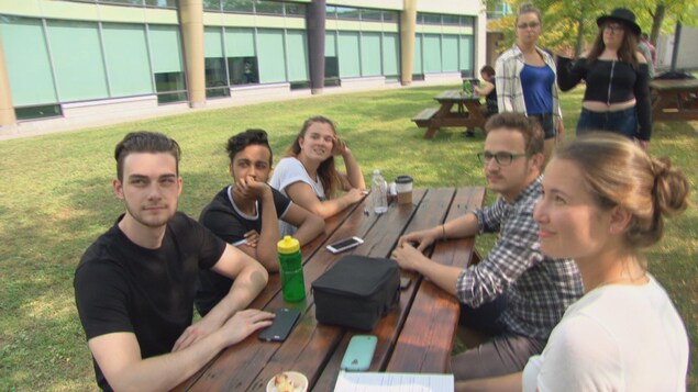 Des jeunes sont assis à une table de pique-nique Des jeunes sont assis à une table de pique-nique