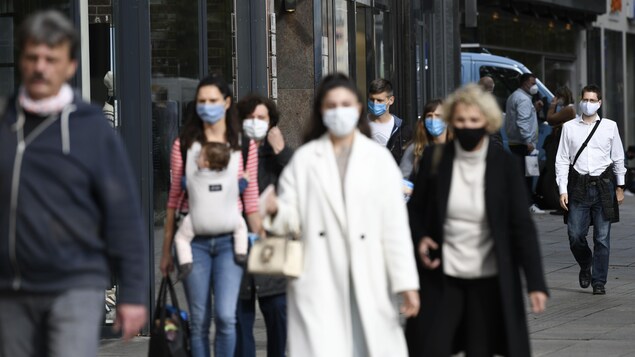 Des passants portant des masques dans une rue de Stuttgart en Allemagne.