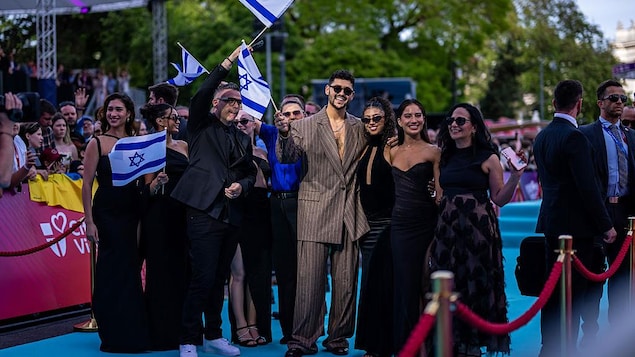 La délégation israélienne défile, en présence de l'artiste, avec des drapeaux israéliens à la main.