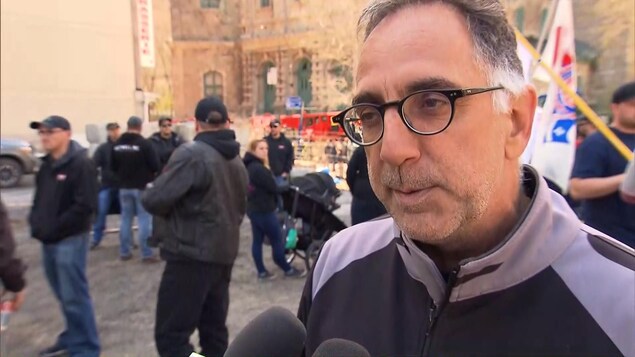 Evans Dupuis porte des lunettes noires, et a les cheveux épars, et poivre et sel Evans Dupuis porte des lunettes noires, et a les cheveux épars, et poivre et sel