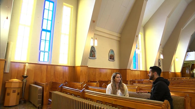 Deux personnes assises sur un banc d'église, face à face