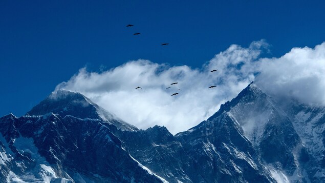 L'Everest sous un ciel bleu et quelques nuages.