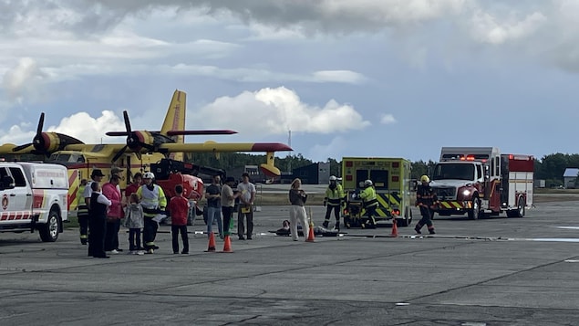 Des pompiers et ambulanciers aident des figurants près d'un avion.