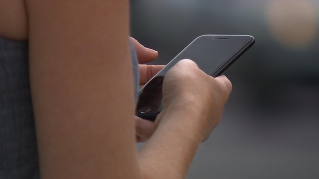 Une personne consulte son téléphone mobile.