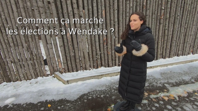 Véronik Picard devant une palissade.