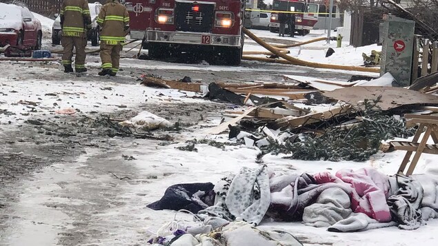 Des pompiers près de plusieurs camions, dans une rue couverte de débris de l'explosion, le 27 mars 2023.