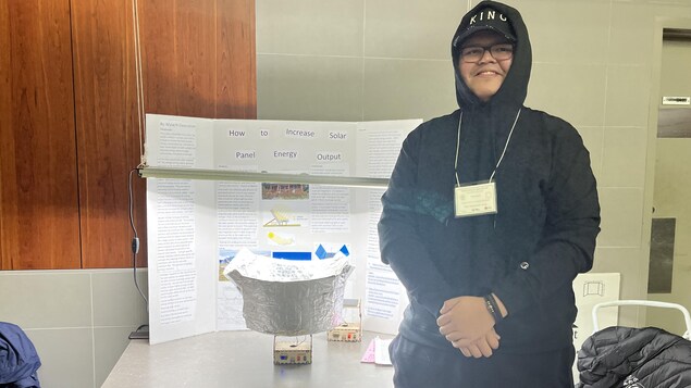 Malachi pose avec son projet.