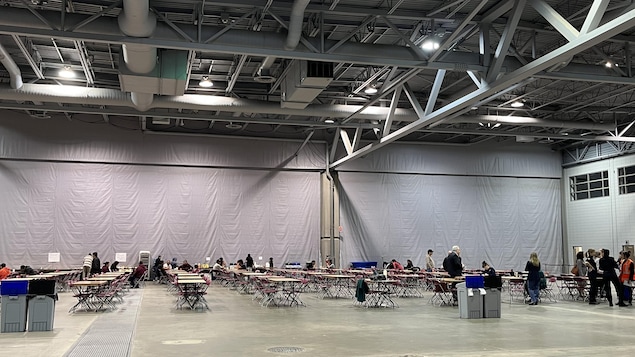 Une grande salle avec des tables.