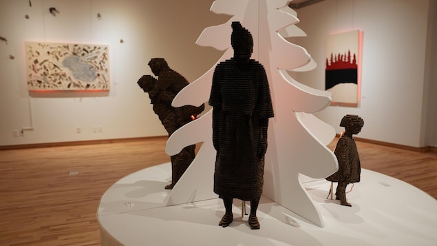 Quatre sculptures représentant des silouhettes de personnes à différents âges. 