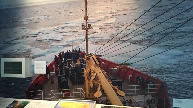 Une photo de l'exposition montre un bateau qui navigue sur une étendue d'eau couverte de glace.