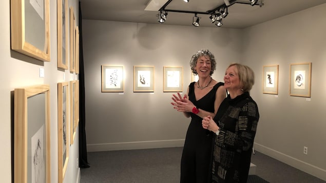 Deux femmes devant des oeuvres exposées dans une galerie d'art