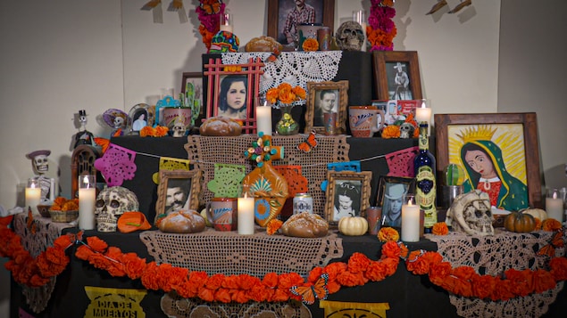 Autel en 3 niveaux dédié à la mort avec des bougies, des photos, des têtes de morts, des petits cadres photos et bien plus. Il s'agit d'une offrande mexicaine d'une artiste pour les membres de sa famille.