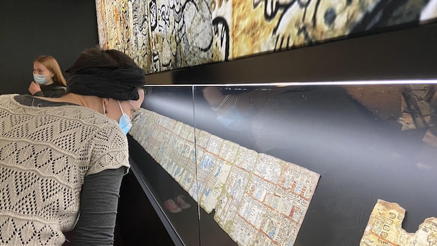 Une femme regarde des artéfacts dans l'exposition «Maya».