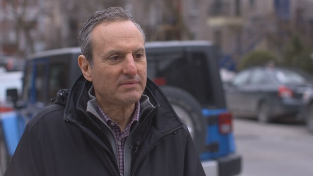 George Iny regarde le journaliste lors d'une entrevue sur le trottoir d'une rue résidentielle. George Iny regarde le journaliste lors d'une entrevue sur le trottoir d'une rue résidentielle.