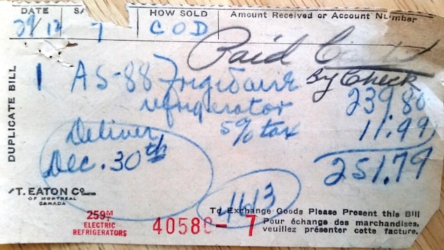 Sur une table en bois, une facture écrite à la main pour l'achat d'un frigo au coût de 271 dollars en 1953. Sur une table en bois, une facture écrite à la main pour l'achat d'un frigo au coût de 271 dollars en 1953.