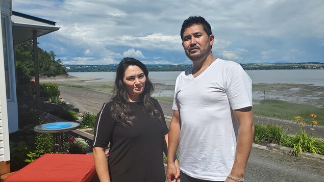 Un homme et une femme prennent la pose pour être photographiés. Ils sont en extérieur.