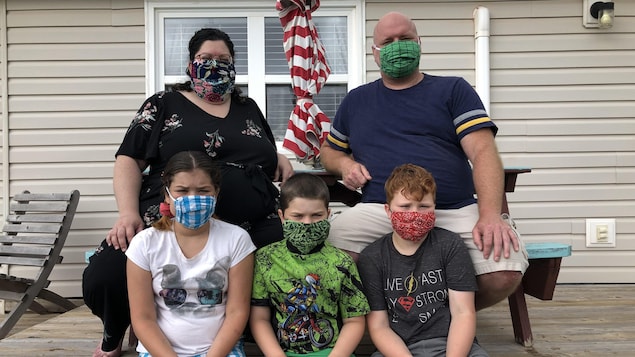Les parents et trois enfants tous masqués.