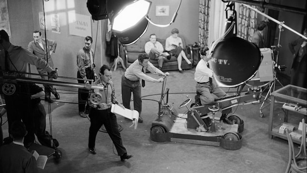 Techniciens et équipement sur le plateau de tournage de l'émission La Famille Plouffe. Techniciens et équipement sur le plateau de tournage de l'émission La Famille Plouffe.