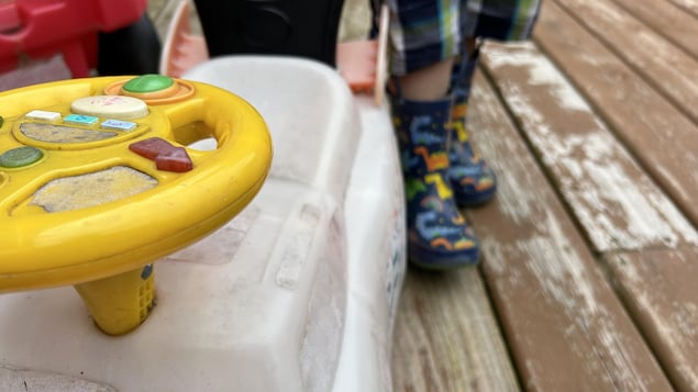 Des bottes d’enfants derrière un jouet.