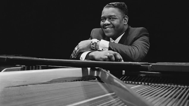 Le pianiste et auteur-compositeur-interprète Fats Domino est assis contre son piano en 1967. Le pianiste et auteur-compositeur-interprète Fats Domino est assis contre son piano en 1967.